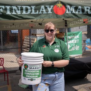 A Findlay Market employee holds a composting bucket.