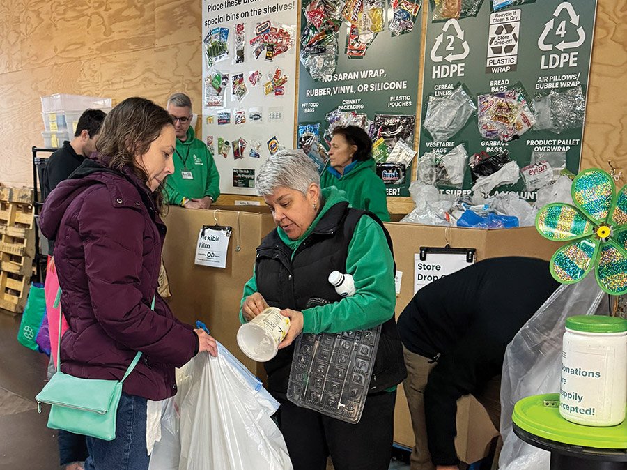 Carrie Harms helps a customer sort her recyclables.